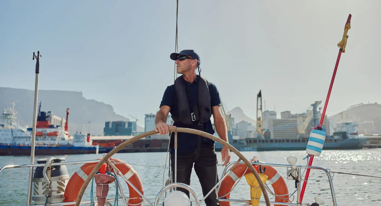 Boat, wheel and crew captain, man or driver driving ship, sailing or cruise for ocean patrol, safety or protection. Navigation journey, yacht travel and person for sea security or rescue services