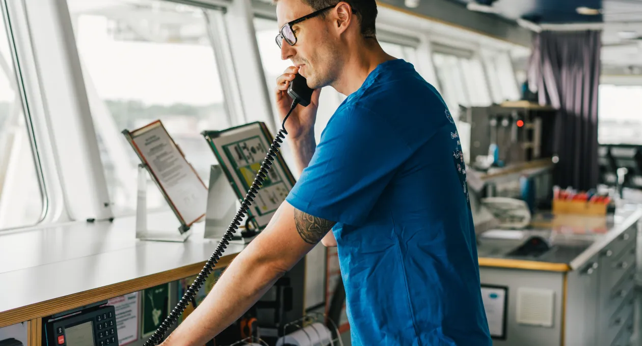 Man using a hand-held device on boat while navigating