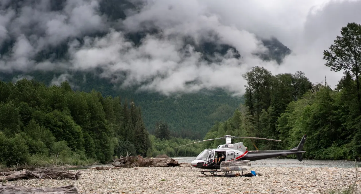 Helicopter on the ground, beautiful cloud covered mountains in the background