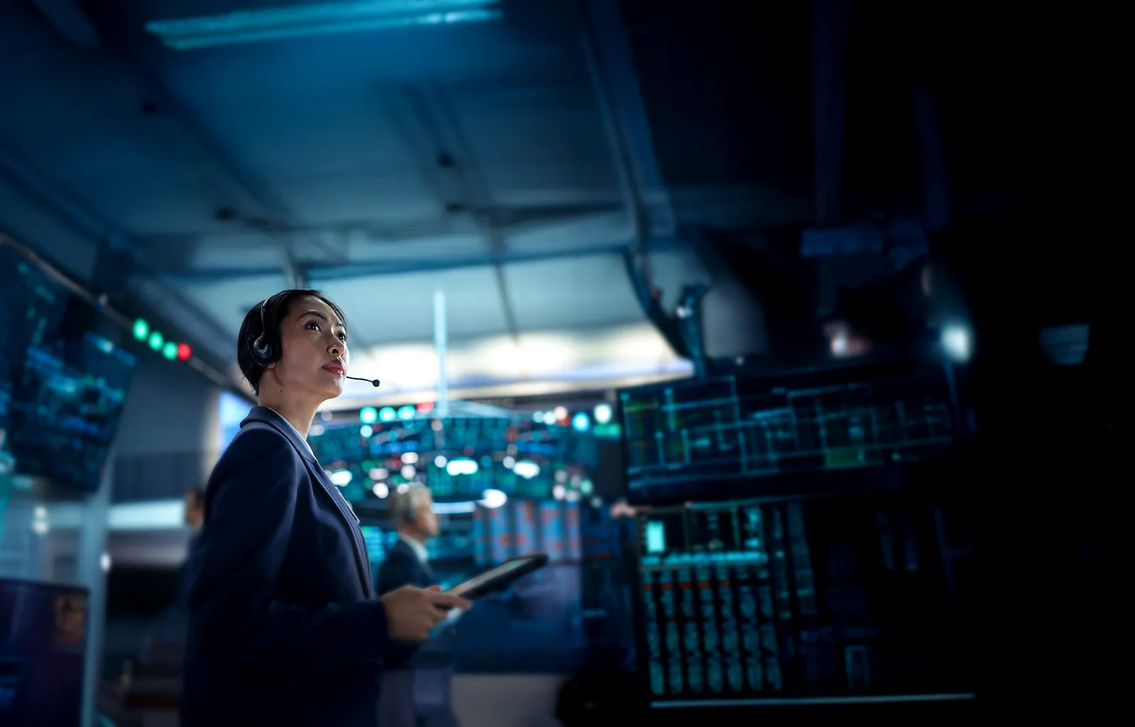Young Asian Female Broker Working on Tablet Computer on Stock Exchange Floor. Traders Monitoring Real-Time Stocks, Commodities and Exchange Market Data. Professional Investment Agents in Office
