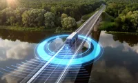 Autonomous semi-truck with a trailer, controlled by artificial intelligence, drives over a bridge over the river. Cargo delivery, transportation of the future. Artificial intelligence. Self driving.