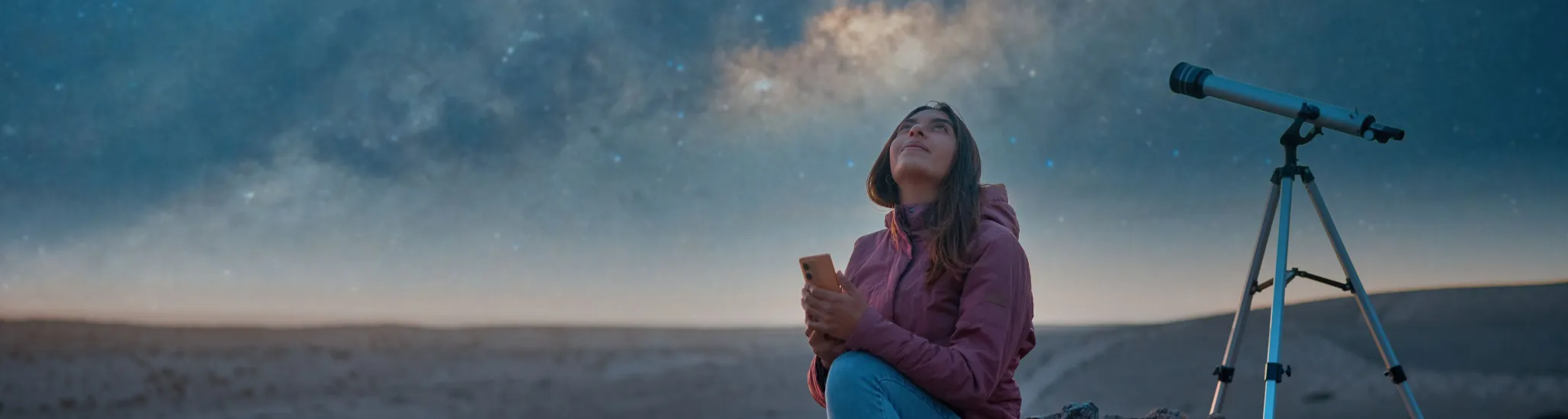 Latina woman sitting in the desert alone watching the starry sky and the milky way in the background