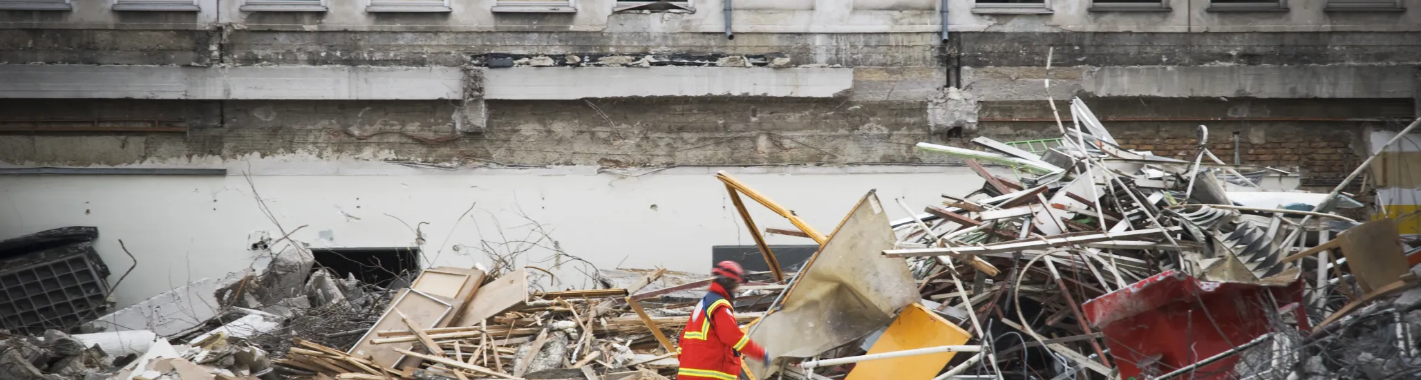 rescue man with dog searching for humans in a destroyed building