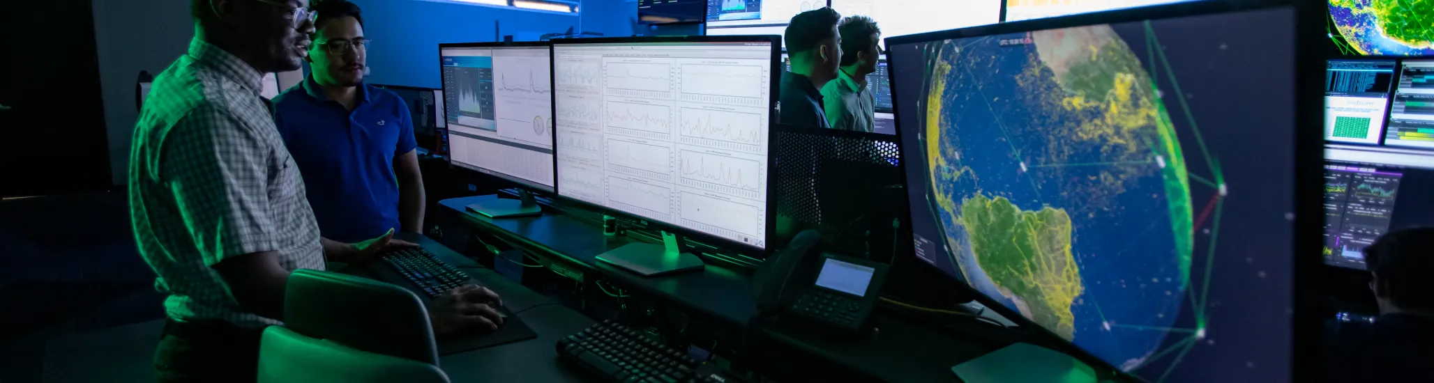 Two employees talking in front of a computer monitor