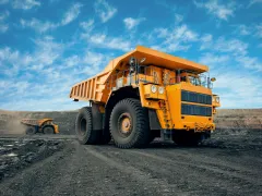 A large quarry dump truck in a coal mine. Loading coal into body work truck. Mining equipment for the transportation of minerals.