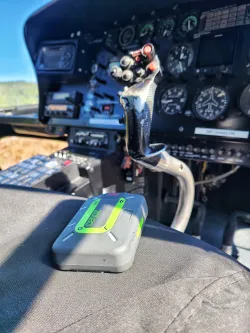 Zoleo devide siting in a helicopter cockpit