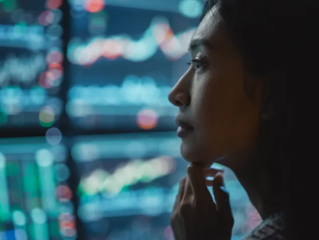 Close Up Portrait of Financial Analyst Working on Computer with Multi-Monitor Workstation with Real-Time Stocks, Commodities and Exchange Market Charts. Businesswoman at Work in Investment Agency.