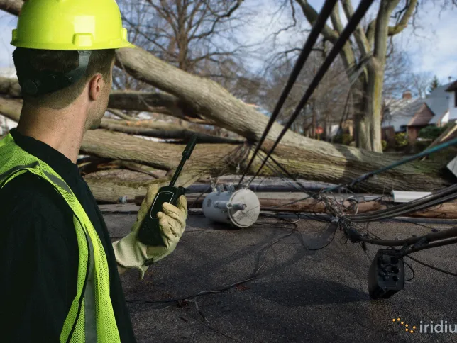 A worker uses Iridium Extreme PTT at a cleanup site