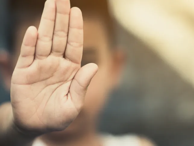 A person holding their hand up in a stop gesture