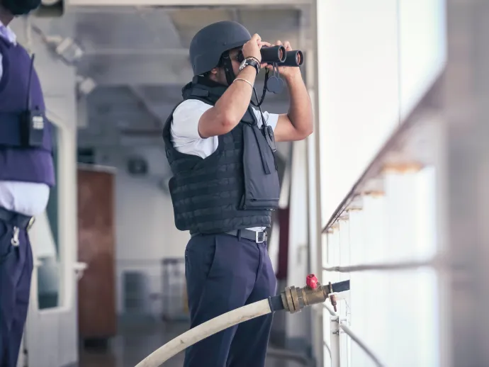 Security officer is performing a Pirate attack drill onboard of a cruise ship sailing the Red Sea off the Somalia coastline. The Captain is super-visioning the operational services with the crew