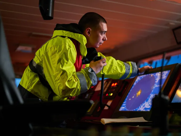 Navigator. pilot, captain as pat of ship crew performing daily duties with VHF radio, binoculars, logbook, standing nearby to ECDIS and radar station on board of modern ship with high quality navigation equipment on the bridge. Great design for navigation,