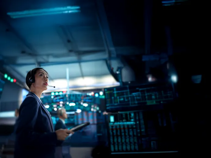 Young Asian Female Broker Working on Tablet Computer on Stock Exchange Floor. Traders Monitoring Real-Time Stocks, Commodities and Exchange Market Data. Professional Investment Agents in Office