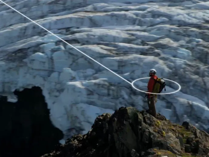 Person standing on a mountain - connecting a satellite phone to a satellite
