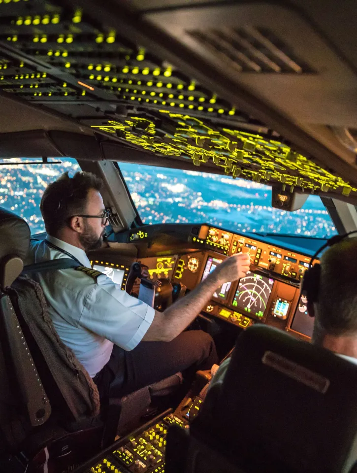 Two pilots at work during departure of Dallas Fort Worth Airport in United States of America. The view from the flight deck with high workload the beginning night through the wind shield