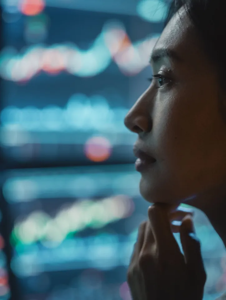 Close Up Portrait of Financial Analyst Working on Computer with Multi-Monitor Workstation with Real-Time Stocks, Commodities and Exchange Market Charts. Businesswoman at Work in Investment Agency.