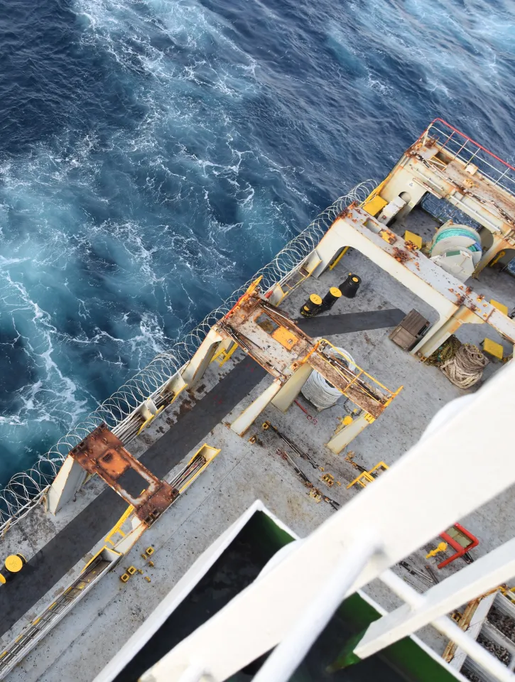 Sharp barbed wire or razor wire attached to the ship hull, superstructure and railings to protect the crew against piracy attack passing Gulf of Guinea in West Africa. Areal or high angle view. 