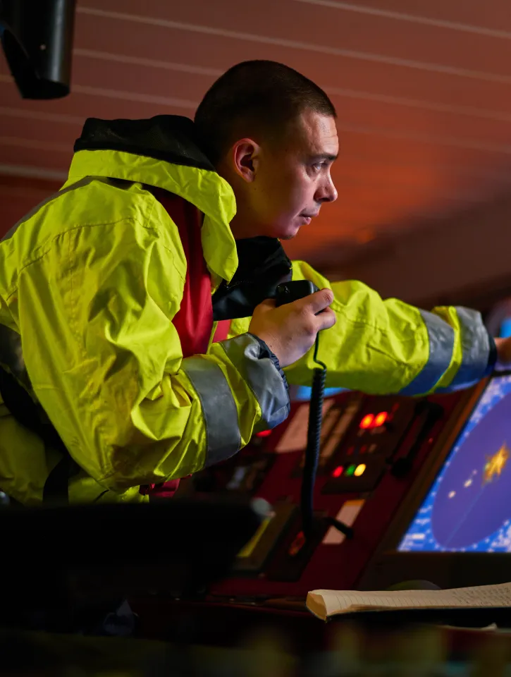 Navigator. pilot, captain as pat of ship crew performing daily duties with VHF radio, binoculars, logbook, standing nearby to ECDIS and radar station on board of modern ship with high quality navigation equipment on the bridge. Great design for navigation,