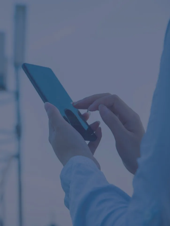 Human hand using mobile phone near 4G,5G communications tower