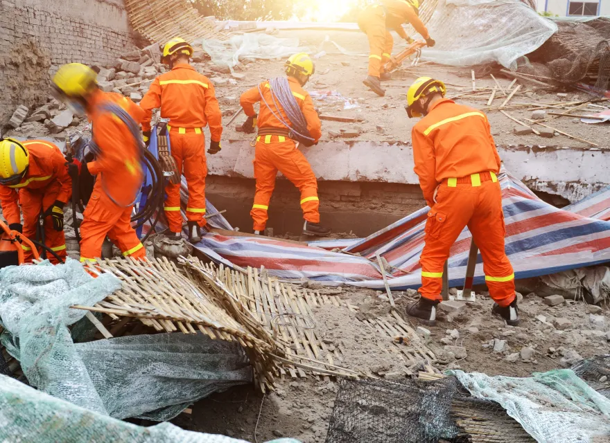 Search and rescue forces searching through a destroyed building.
