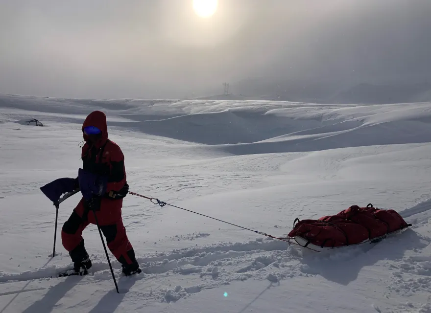 Person trekking through the south pole - pulling a sled of equiptment