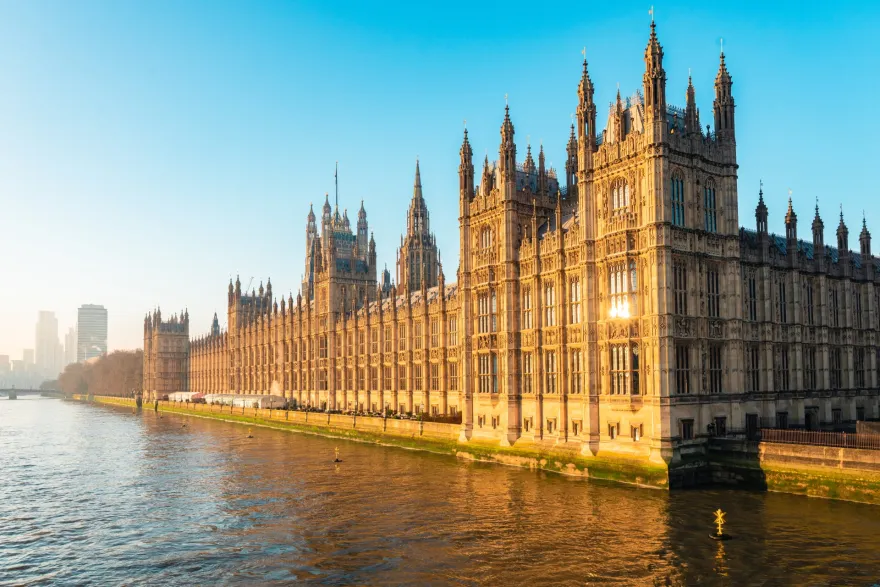 Palace of westminster, houses of parliament, reflecting on river thames at sunset in london, uk
