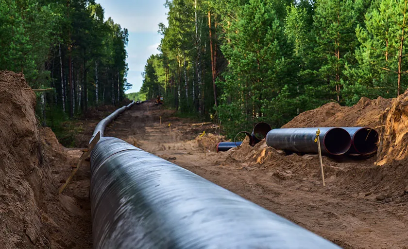 Gas pipeline under construction, trees surround