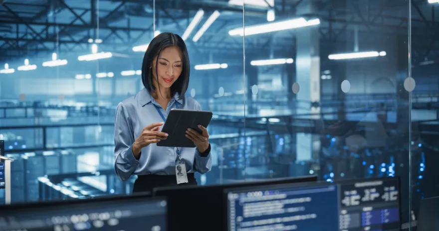 Image of Asian Female Systems Administrator Standing in a Glass Office