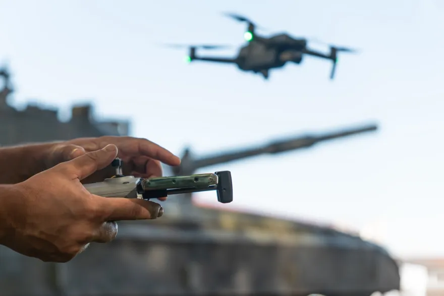 Hands controlling a UAV tank in the background