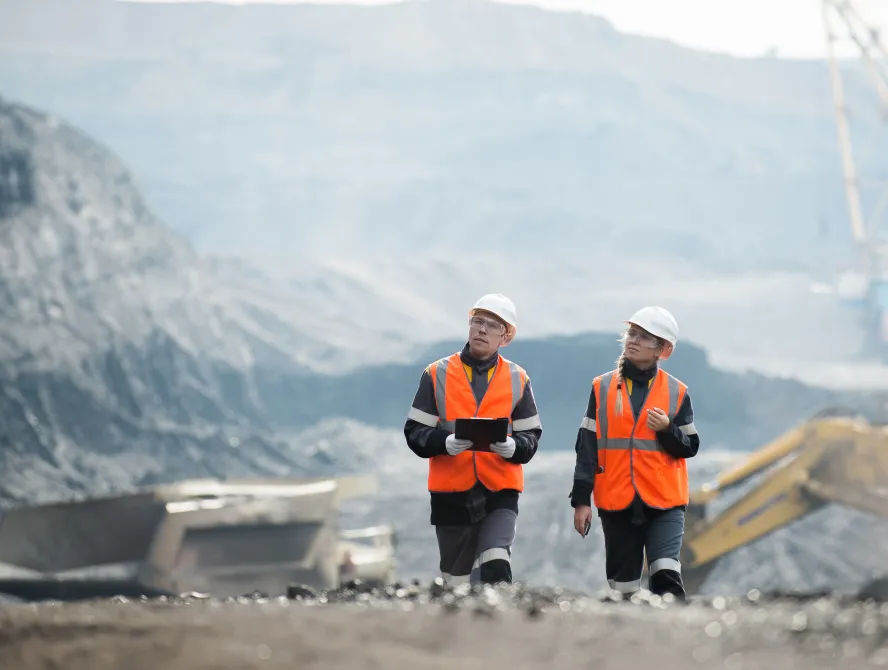 Two speacialists examining coal at an open pit