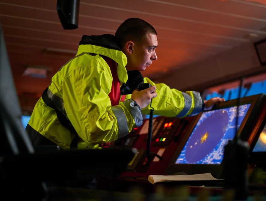Navigator. pilot, captain as pat of ship crew performing daily duties with VHF radio, binoculars, logbook, standing nearby to ECDIS and radar station on board of modern ship with high quality navigation equipment on the bridge. Great design for navigation,