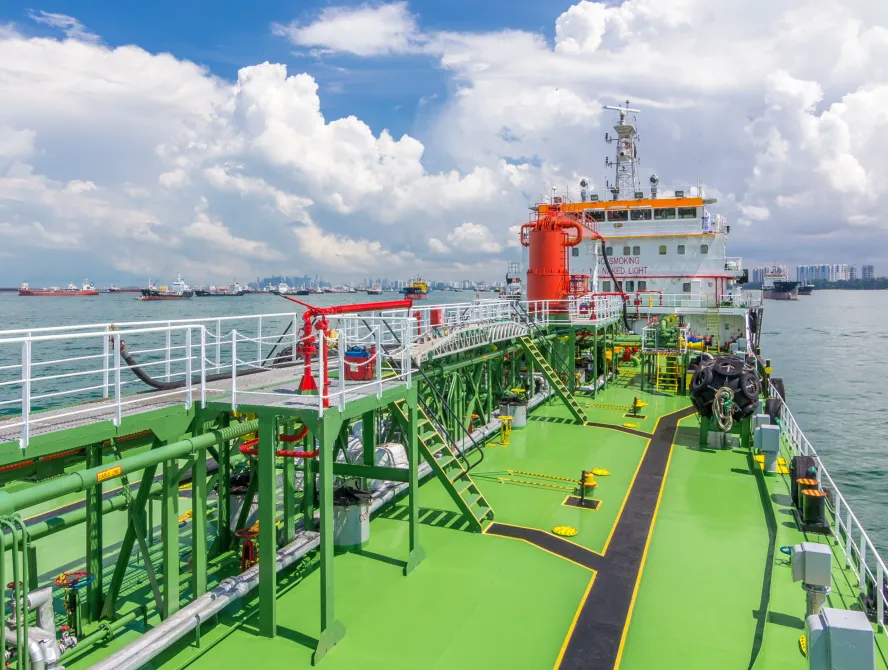 SINGAPORE - CIRCA JUNE 2018: Green deck of the tanker under blue cloudy sky timelapse. Crane with pipe mooving on it by operator