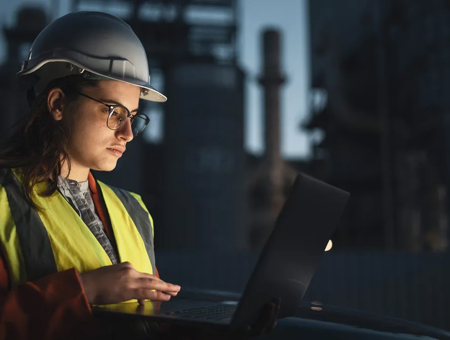 Female engineer at petroleum oil refinery checking IoT dashboard