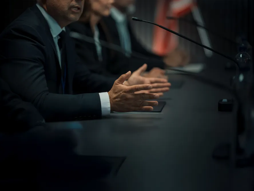Close Up On Hands of Caucasian Male Organization Representative Speaking at Economic Conference. Head Of USA Delegation Delivering Speech at International Political Summit. Diverse Delegates Listening