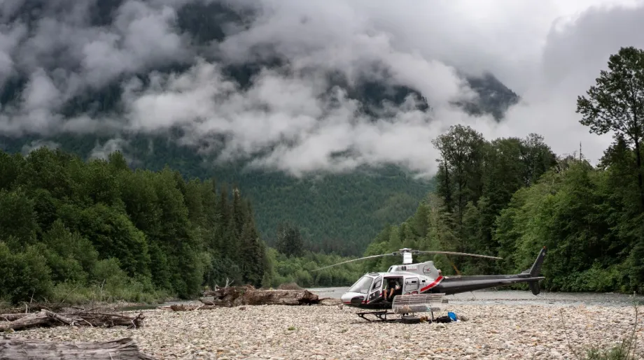 Helicopter on the ground, beautiful cloud covered mountains in the background