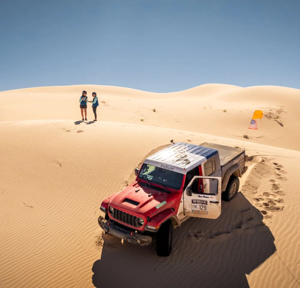 Rally racer in remote desert terrain staying connected via SATCOM.