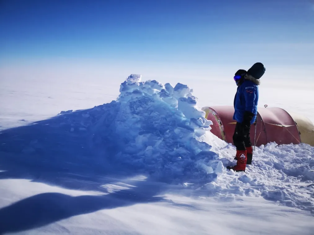 Person standing by a mountain of snow
