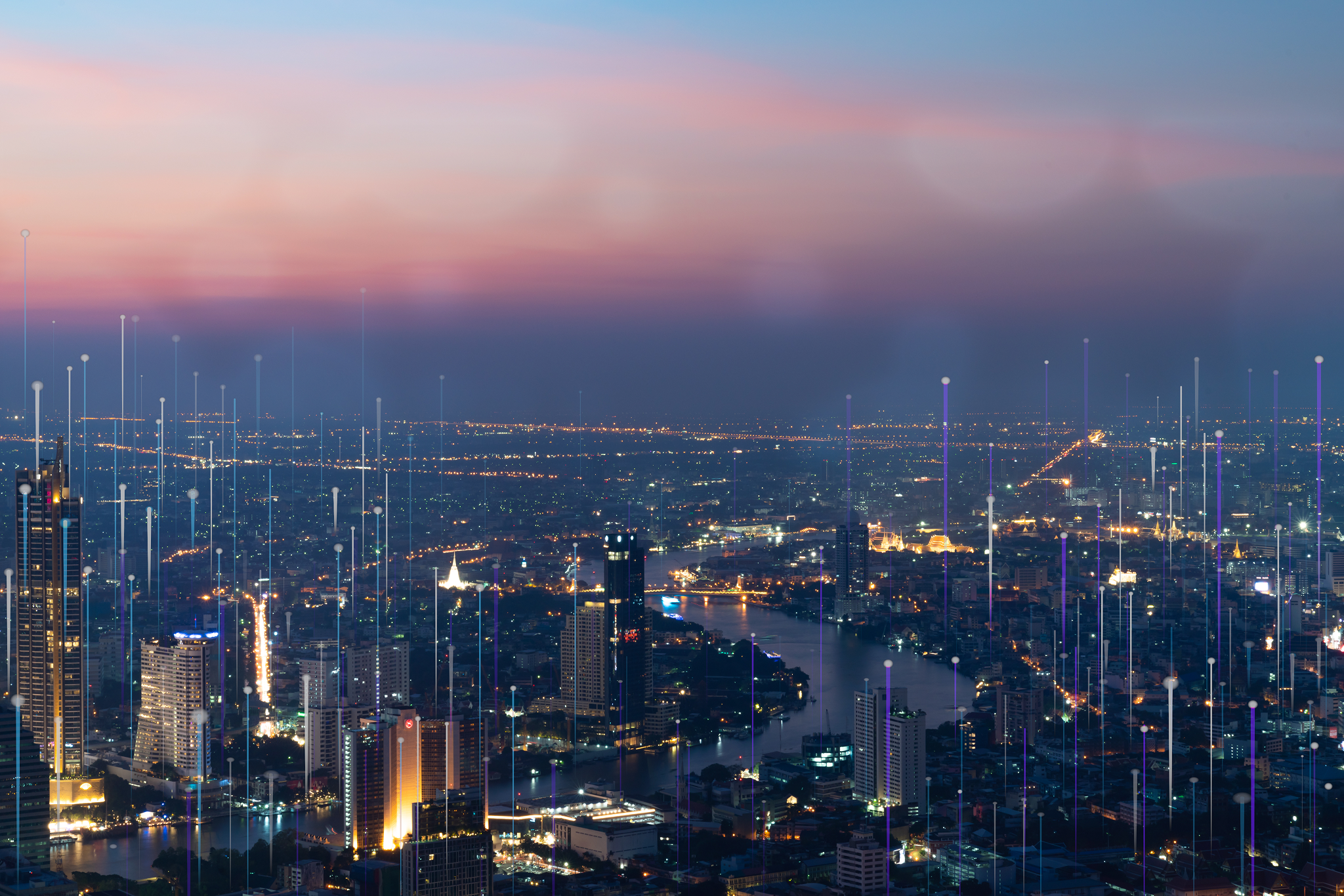 Smart city skyline at dusk with glowing digital network connections.