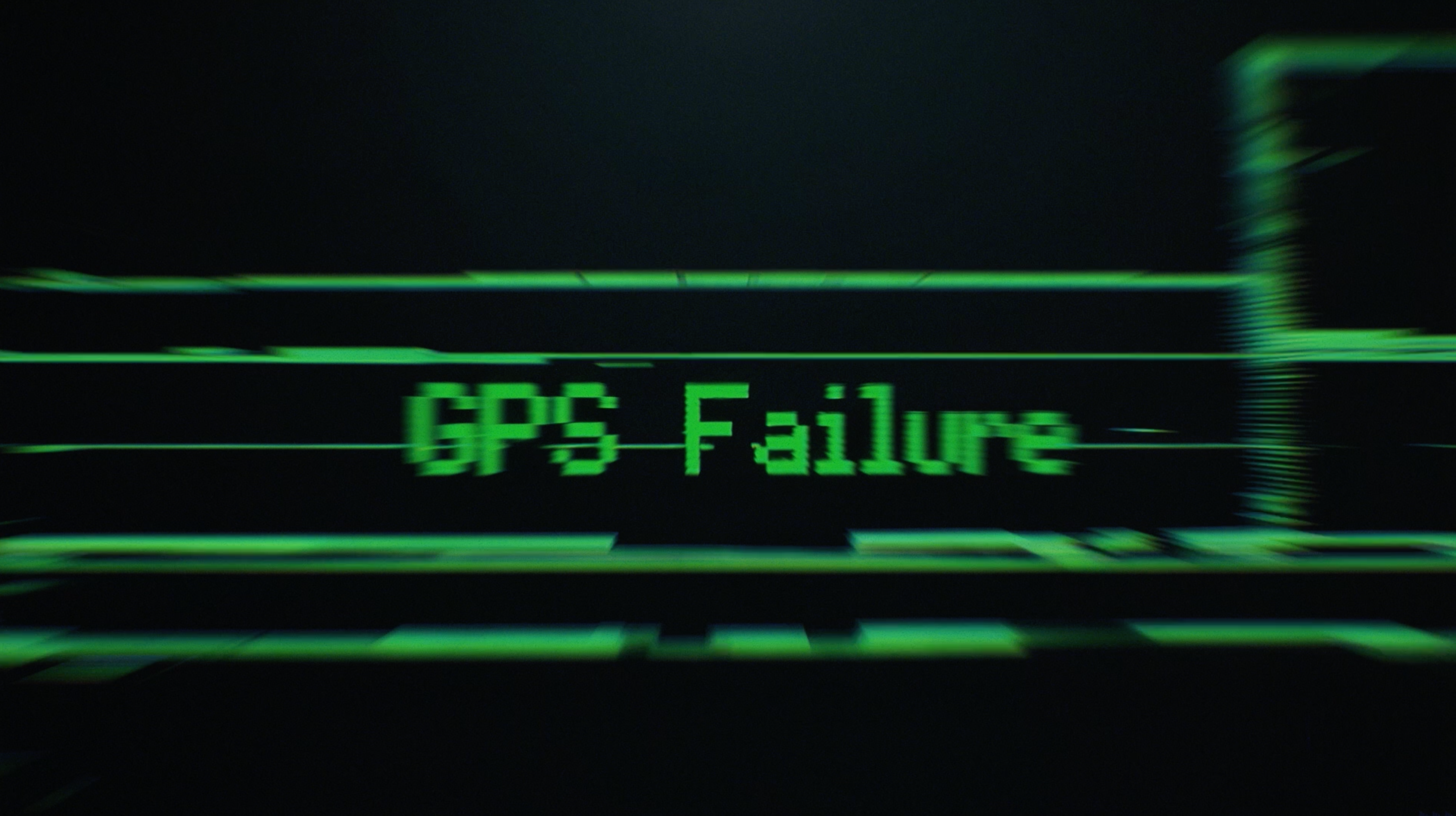 Close-up of a dark digital display showing the words “GPS Failure” in green text.